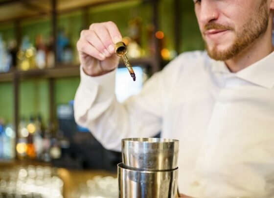 Barman adding bitters to cocktail in a modern pub